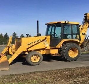 John Deere backhoe loader excavator with front loader bucket and rear digging arm outdoors